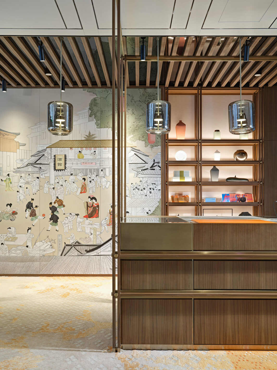 Modern hotel reception with Japanese art mural, wooden shelves with ceramics, and glass pendant lights. Sophisticated and serene atmosphere.