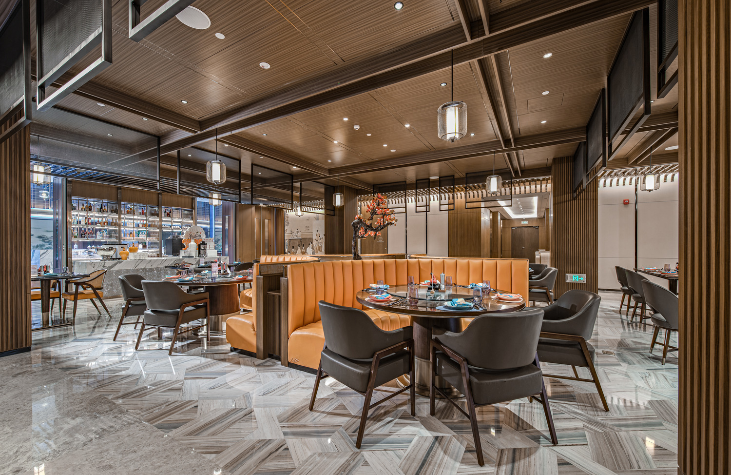 Modern hotel restaurant with elegant decor, featuring turquoise and beige chairs, wooden tables, and striking overhead lights, creating a sophisticated ambiance.