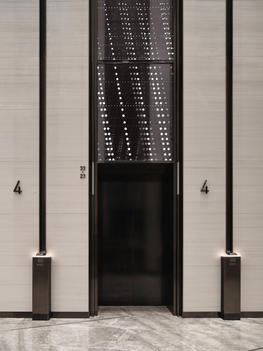 Spacious modern office lobby with geometric ceiling patterns, sleek marble floors, and a minimalist reception desk, conveying a sophisticated and elegant tone.