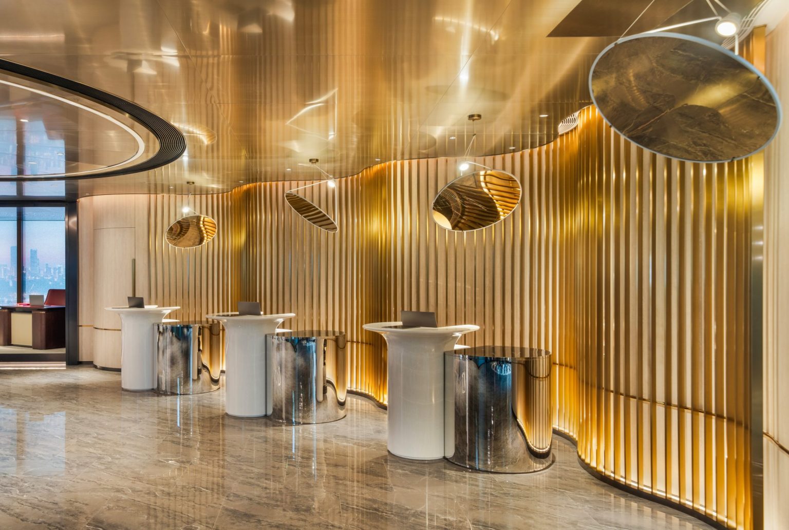 A futuristic hotel reception desk with golden metallic backdrop and cylindrical chandeliers.