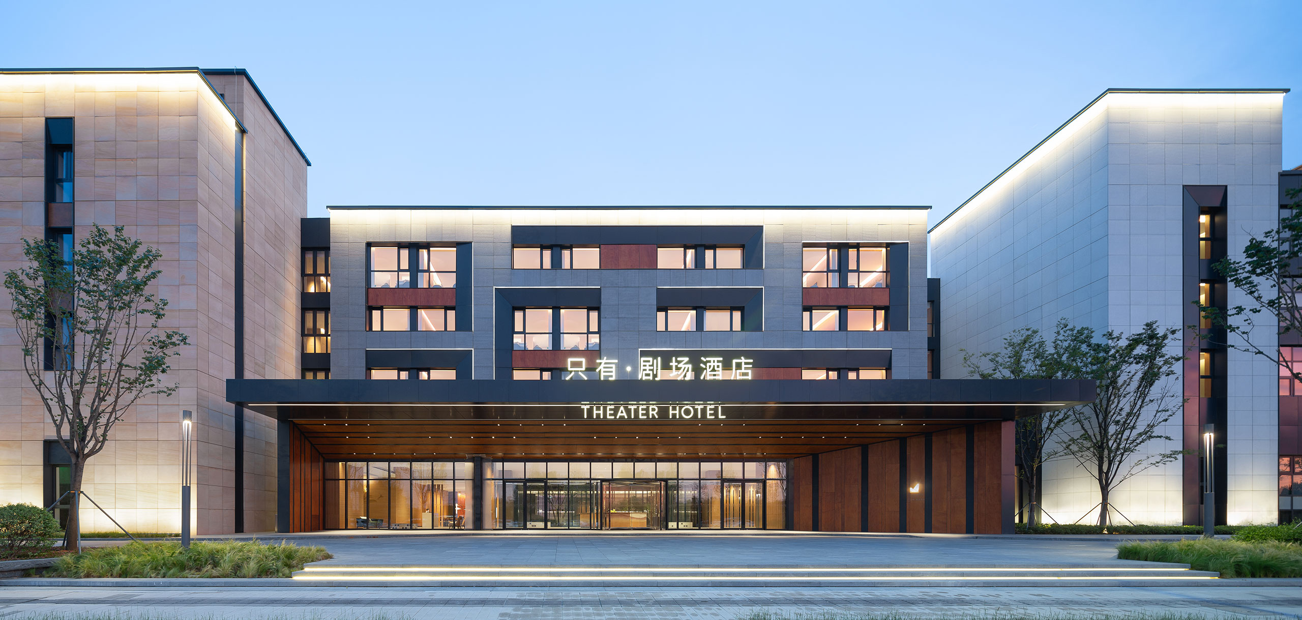 Modern hotel facade at dusk, labeled 