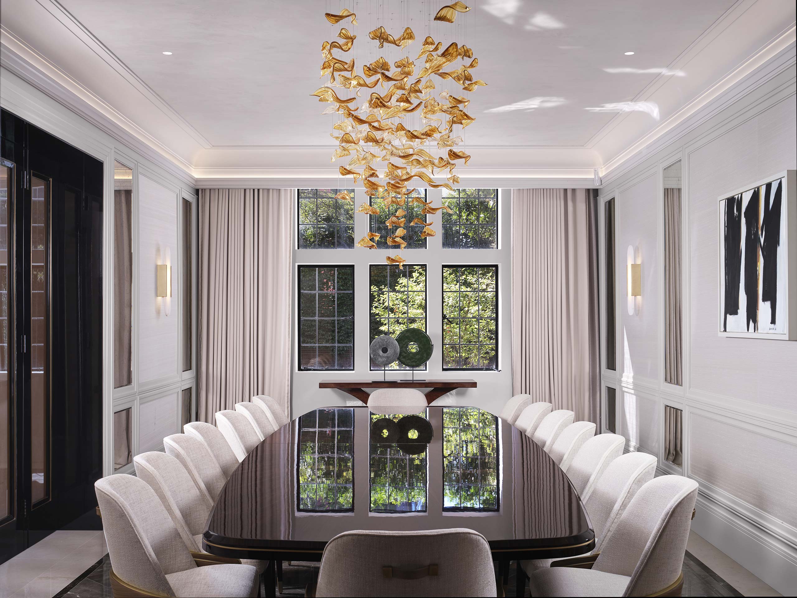 Luxurious dining room with a glossy black oval table surrounded by white chairs. A gold bird-shaped chandelier hangs above. Large windows with beige curtains reveal greenery outside, adding elegance.