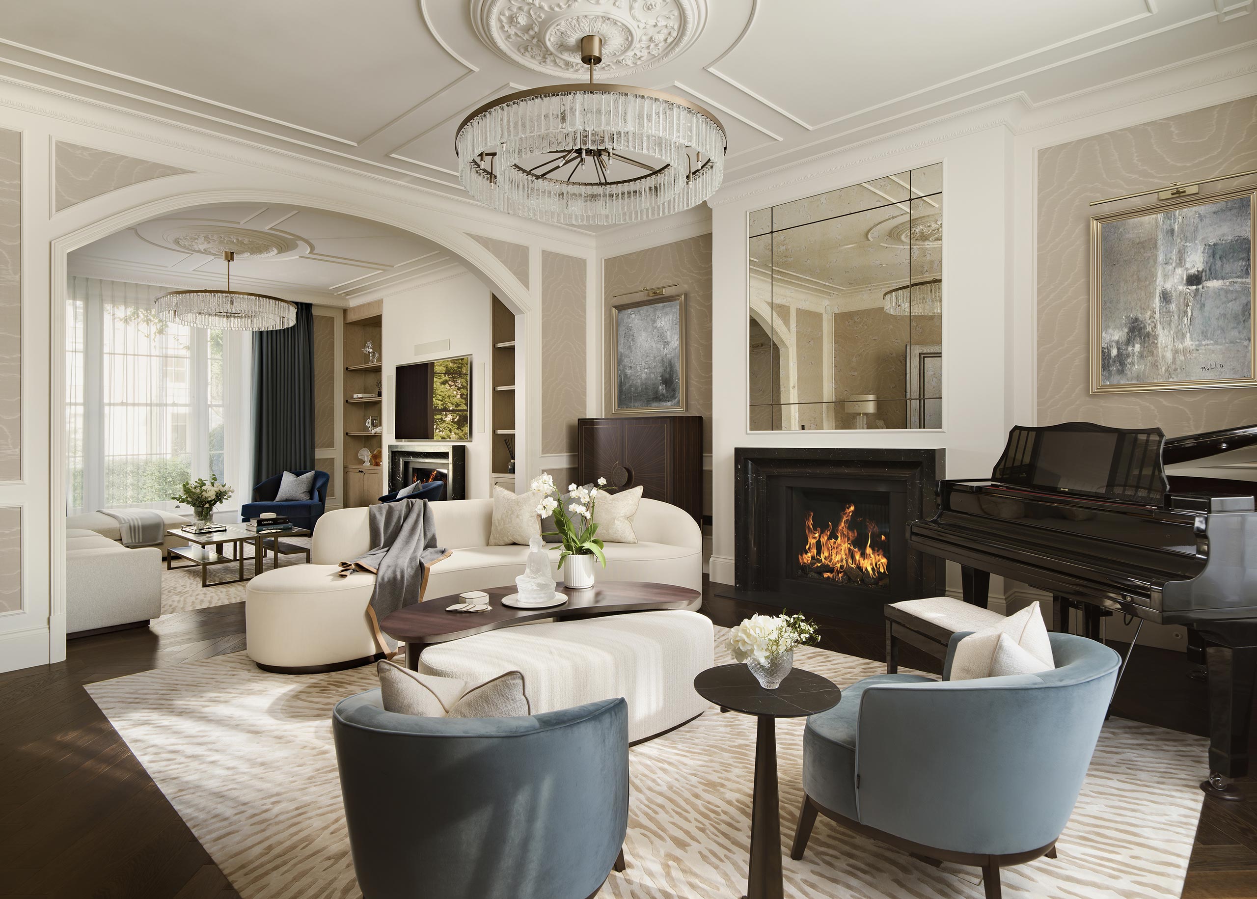 Elegant living room with a lit fireplace, grand piano, and plush seating. Large chandelier, modern art, and soft lighting create a sophisticated ambiance.