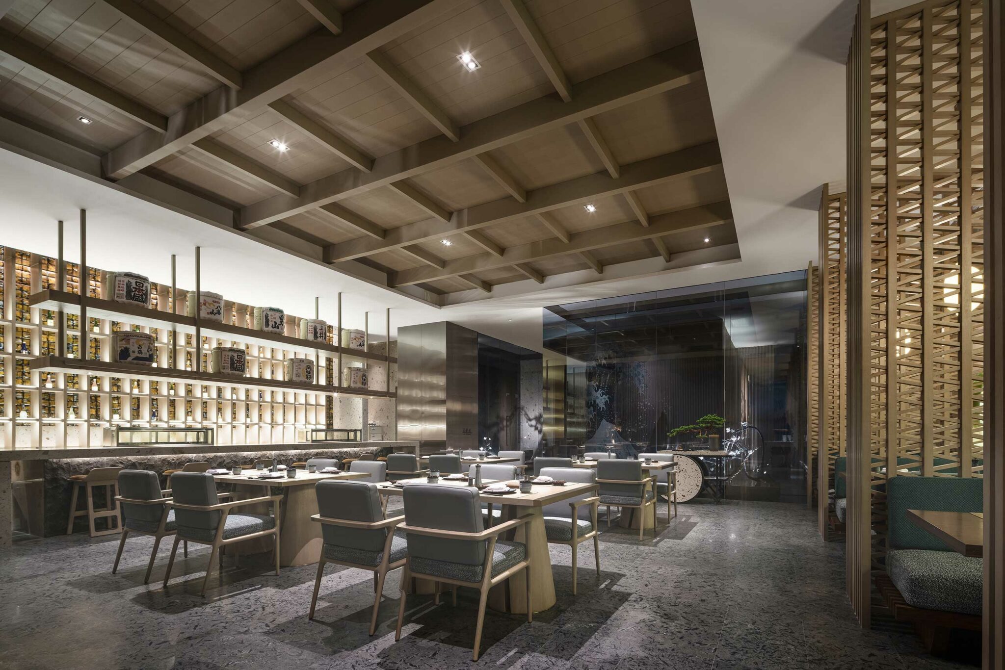 Sophisticated restaurant interior of a luxury hotel with modern decor, featuring wooden ceiling, elegant tables with green chairs, and ambient lighting creating a cozy atmosphere.