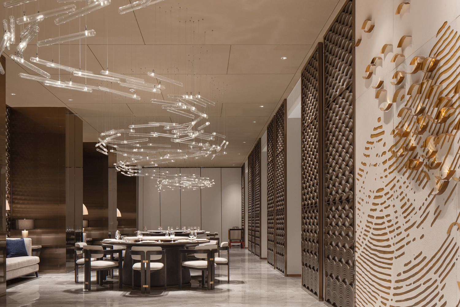 A stylish dining area featuring a modern chandelier, a round table surrounded by elegant chairs, and artistic wall decor, creating a sophisticated atmosphere for gatherings.