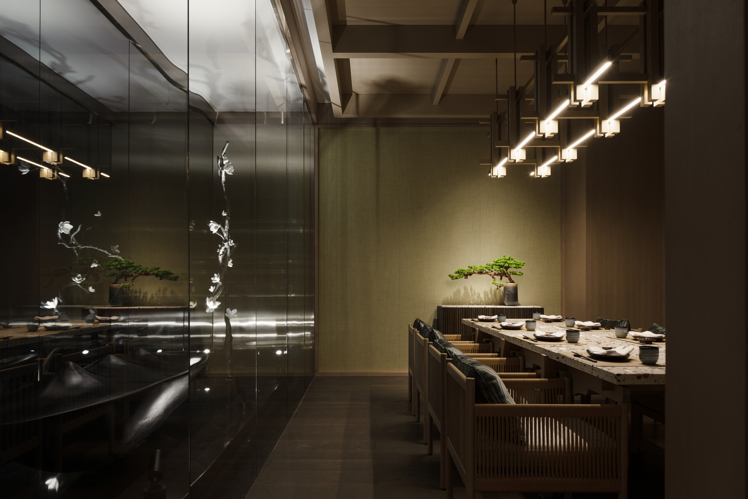 A serene private dining room with a long wooden table, elegant lighting, and decorative bonsai, featuring glass walls that create a calm ambiance for intimate gatherings and Japanese fine dining.