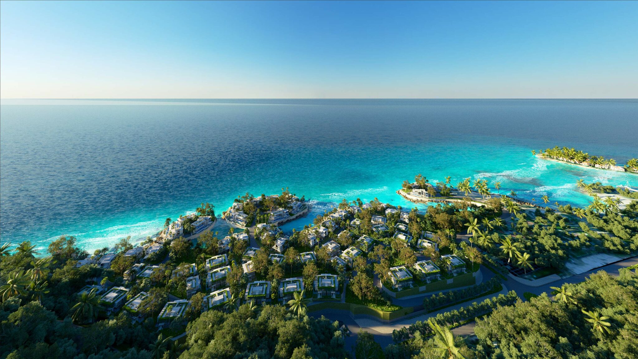 Aerial view of a luxury resort with villas nestled among lush greenery, bordered by clear turquoise ocean under a bright blue sky, conveying tranquility.