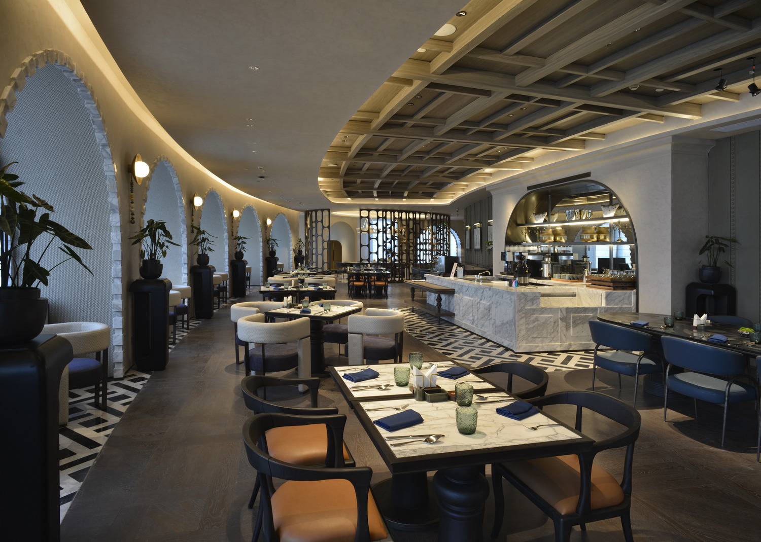 Elegant, dimly lit hotel restaurant interior with a modern bar, stylish seating, patterned floors, and soft ambient lighting, creating a sophisticated atmosphere.