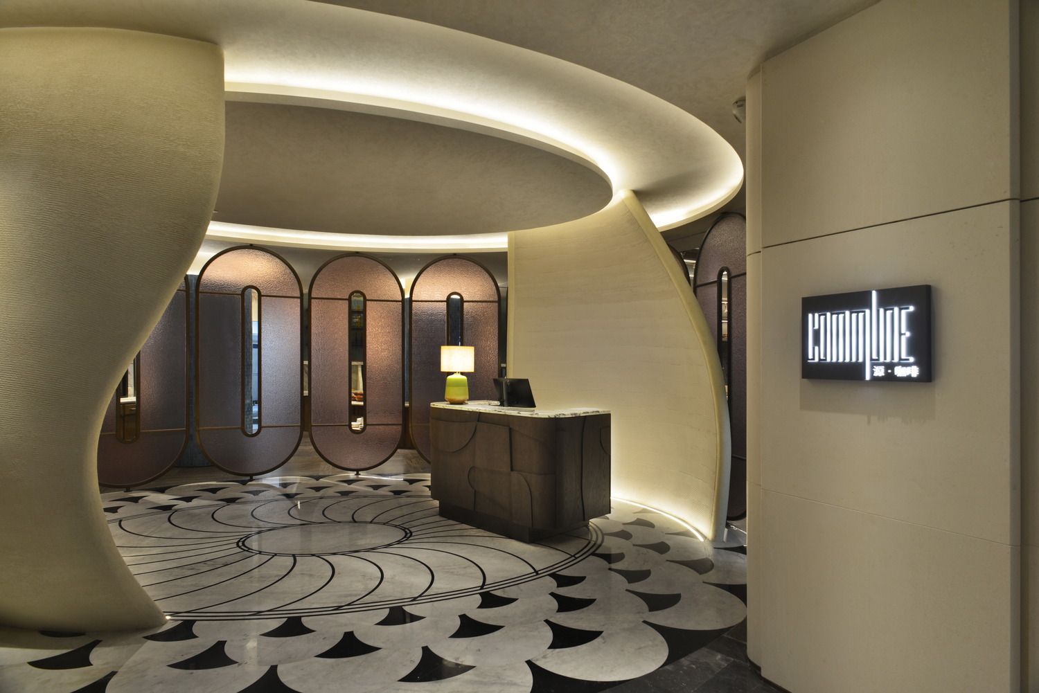 Luxurious hotel lobby with plush chairs, marble tables, and lush greenery. A grand spiral staircase adds elegance. Warm, sophisticated ambiance.