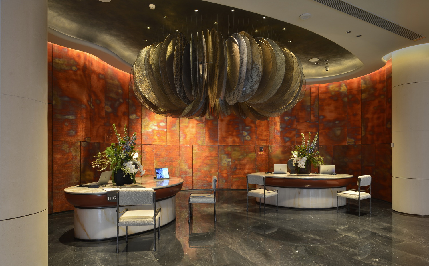 Luxurious hotel lounge with elegant furniture, soft lighting, and a marble bar. The modern design features curved architecture, plush seating, and warm tones.