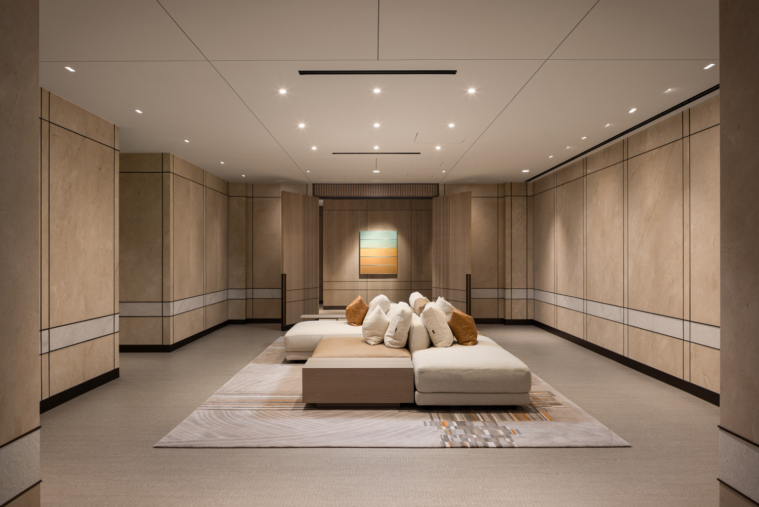 Sophisticated modern office lounge with beige decor, plush seating, and a sleek glass fireplace. Floor-to-ceiling windows and greenery create an airy, relaxing atmosphere.