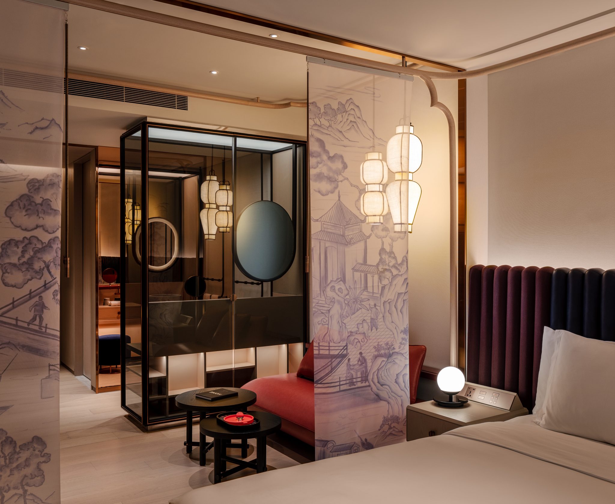 Elegant hotel room with a plush king-size bed, modern pendant lighting, and a sleek en-suite bathroom. Neutral tones create a calm, luxurious ambiance.