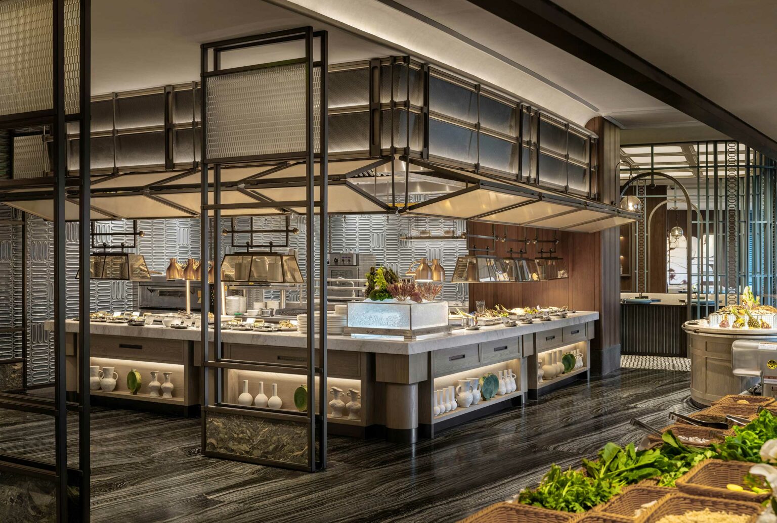 Luxurious buffet setup in a stylish, modern hotel all day dining area. Metal frames and shelves display dishes. Warm lighting adds an inviting, elegant atmosphere.