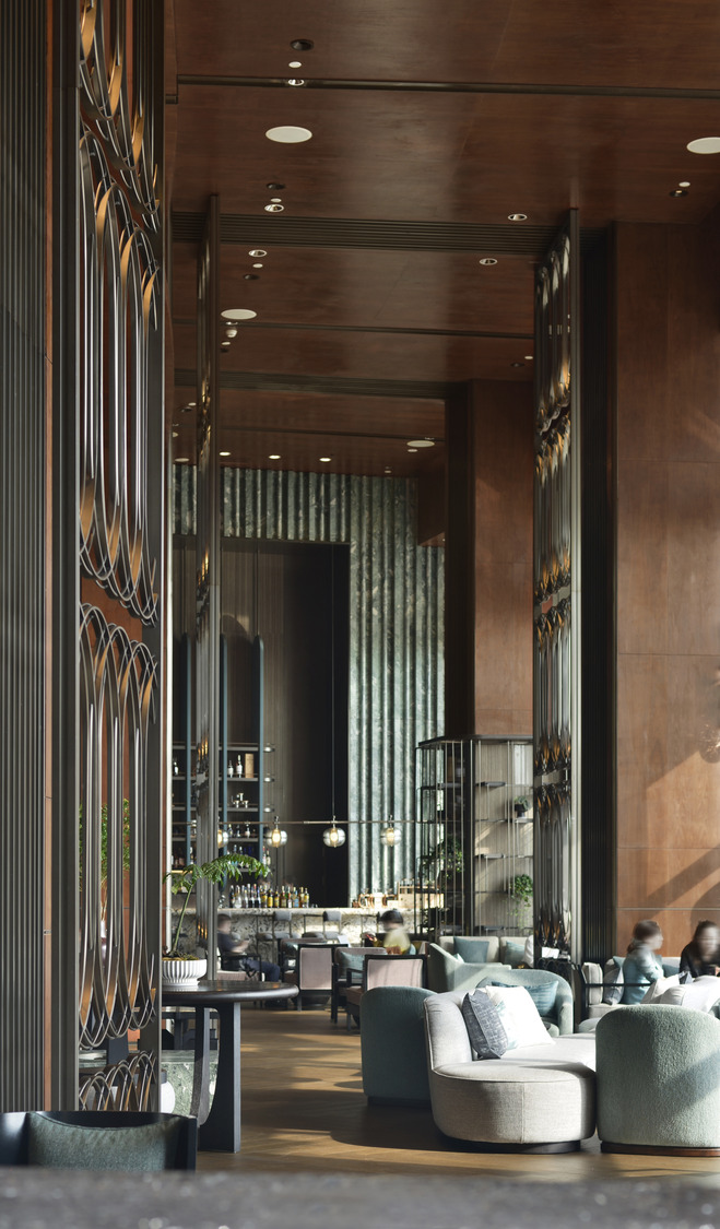 Luxurious hotel lounge with modern decor, featuring a wavy teal wall, linear fireplace, round seating, ambient lighting, and a leafy green plant.