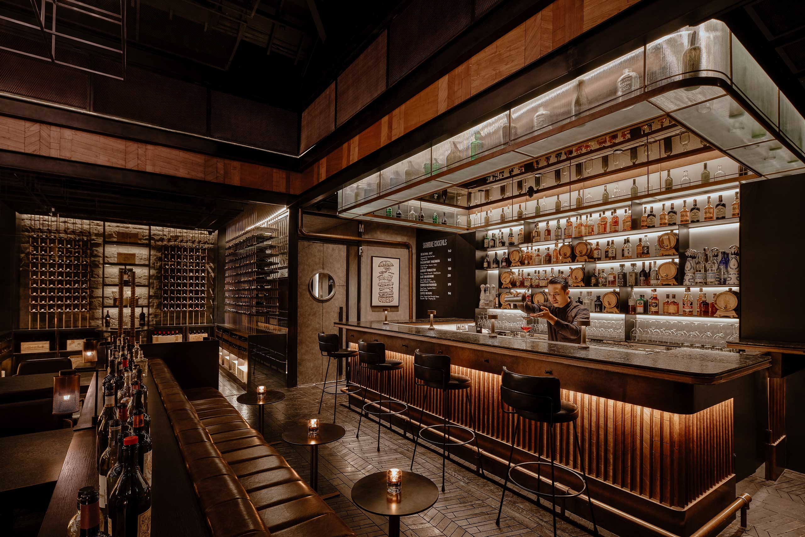 Sophisticated restaurant bar with dim lighting, featuring shelves of liquor bottles, a bartender mixing a drink, leather stools, and a cozy, elegant ambiance.