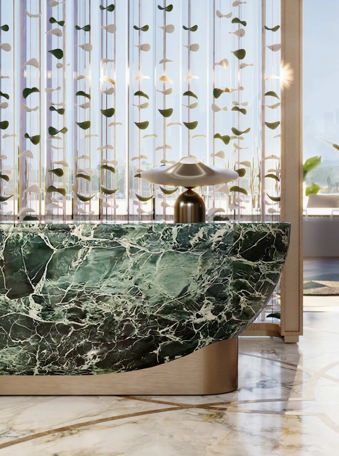 Sleek lobby with a green marble counter, brass lamp, and decorative hanging elements. Sunlight filters through a large window, creating a serene atmosphere.