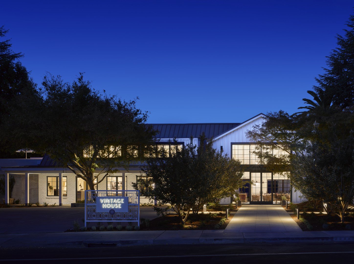 Illuminated hotel exterior at dusk, labeled 