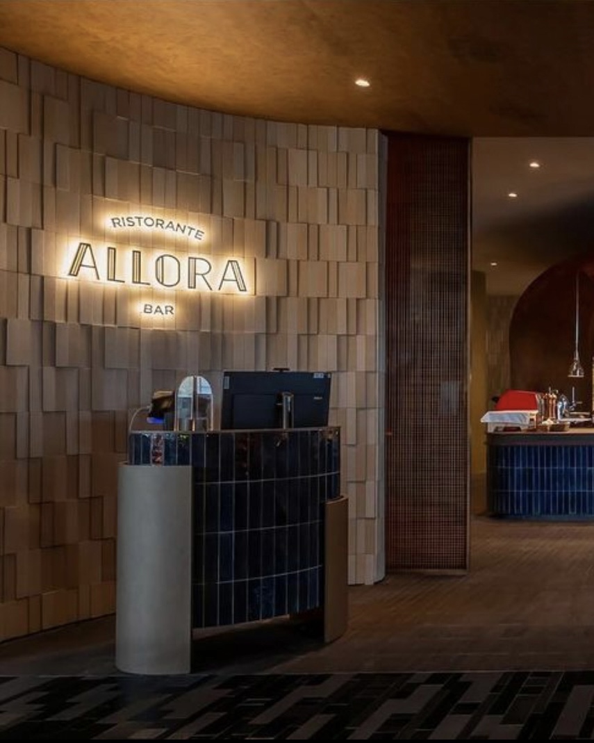 A warmly lit restaurant entrance with a sign reading 