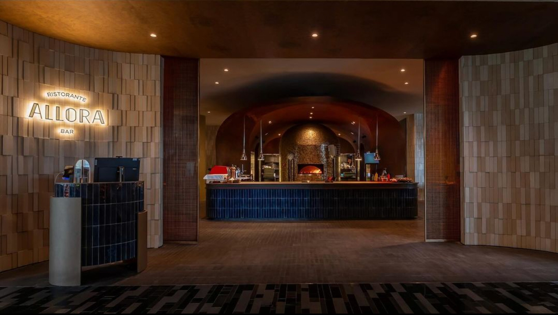 A warmly lit restaurant entrance with a sign reading 