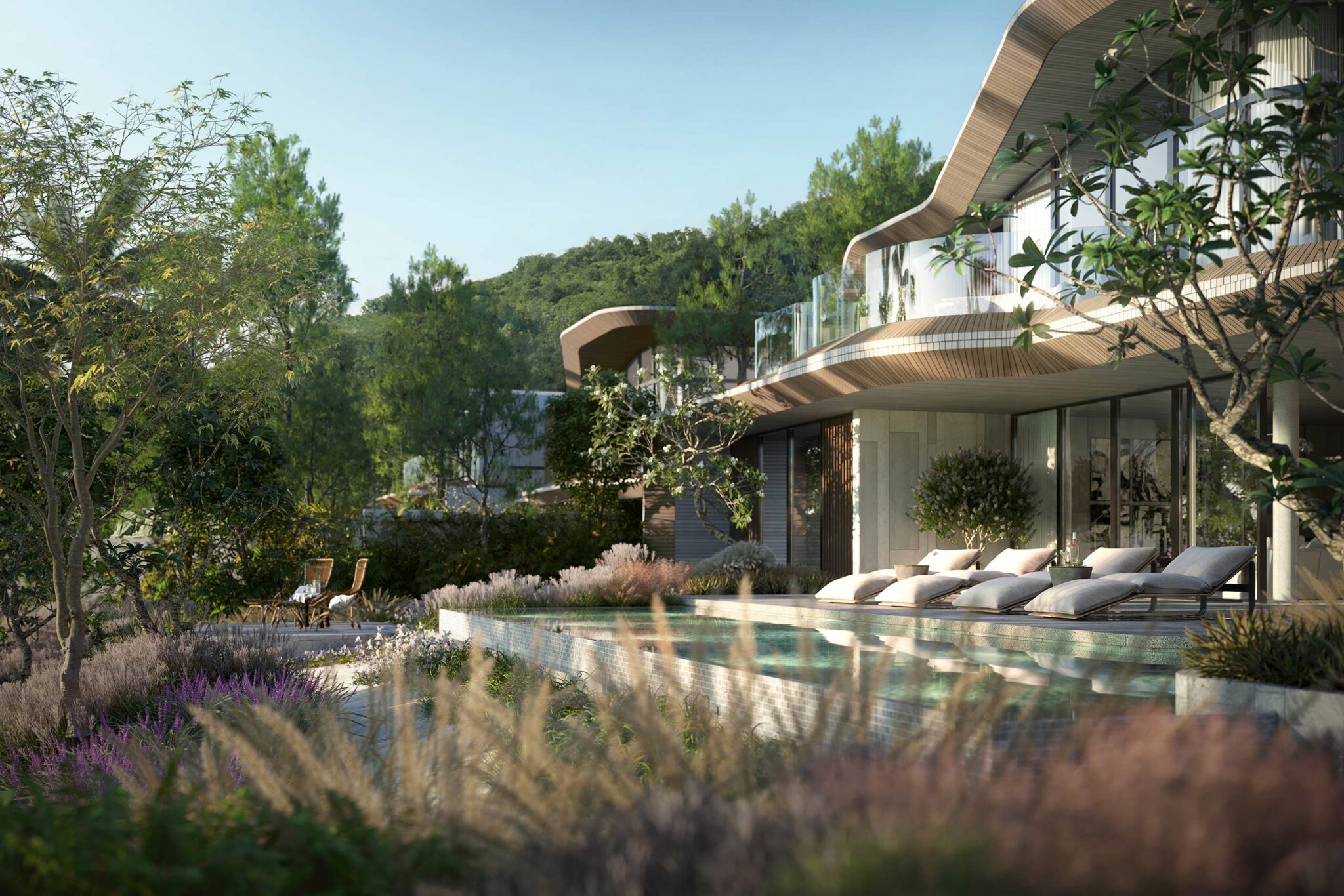 Modern hotel with glass walls, curved roof, and lounge chairs beside an outdoor pool. Surrounded by lush greenery and hills under a clear sky.