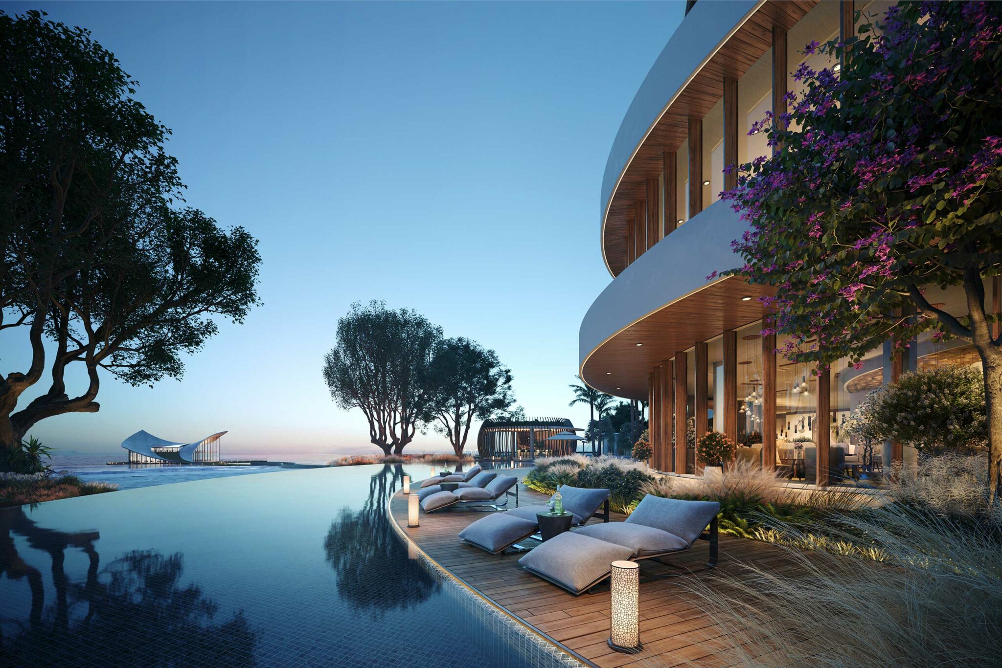 Modern beachfront hotel at sunset, featuring a sleek infinity pool surrounded by loungers and lush trees. The atmosphere is tranquil and luxurious.