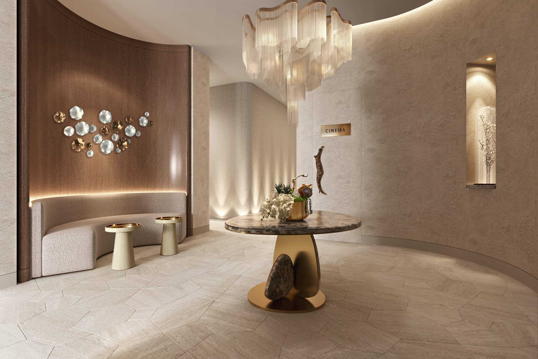 Elegant home theater lobby with a marble table, gold accents, and soft lighting. A modern chandelier hangs above, with abstract wall art and a sign for a cinema.