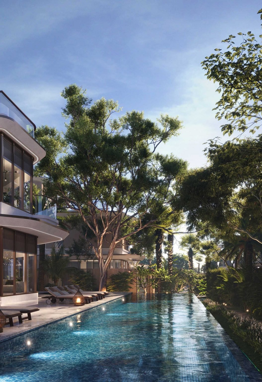 A serene poolside view featuring modern villas surrounded by lush greenery and trees, with sun loungers and soft lighting, creating a tranquil and inviting atmosphere for relaxation.