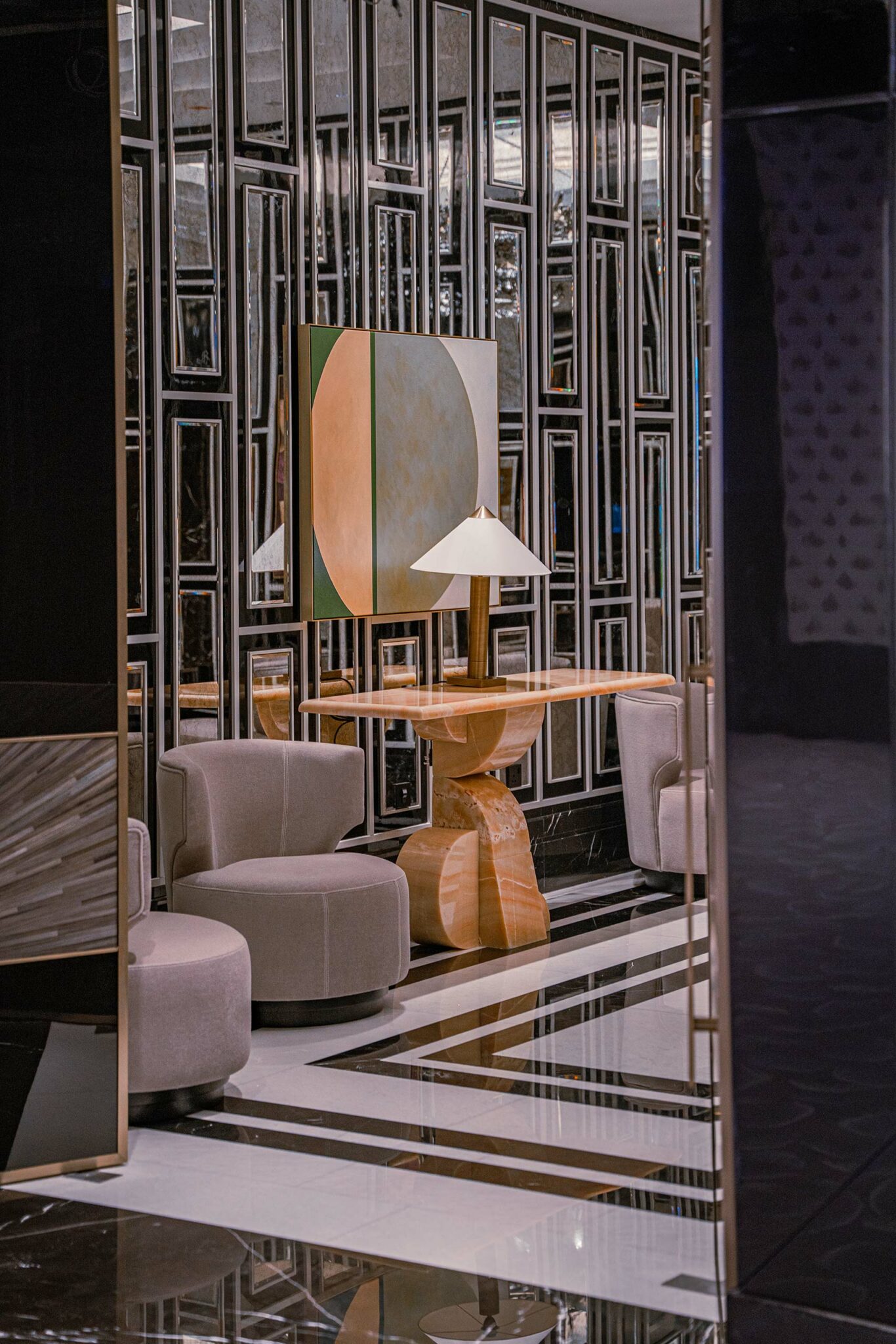 Luxurious hotel board room with mirrored walls, geometric art, elegant beige chairs, and a sculptural wooden table with a lamp, creating a sophisticated atmosphere.