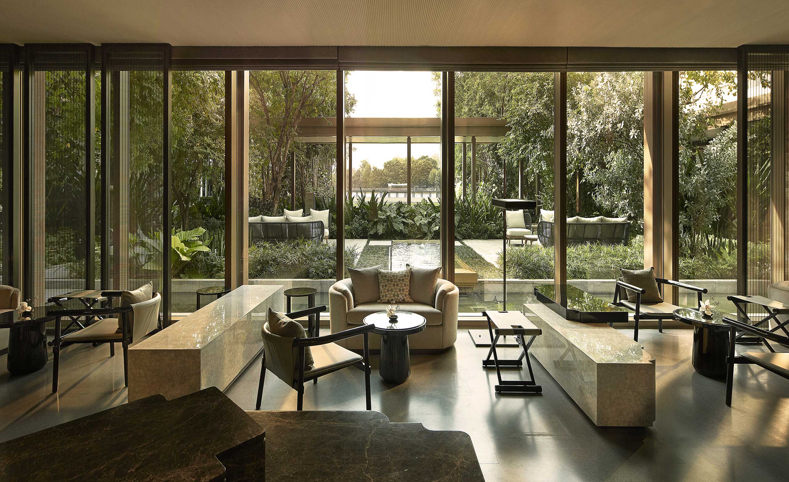 Luxurious hotel spa lounge with modern furniture, large windows, and garden views. Soft lighting creates a serene and inviting atmosphere.
