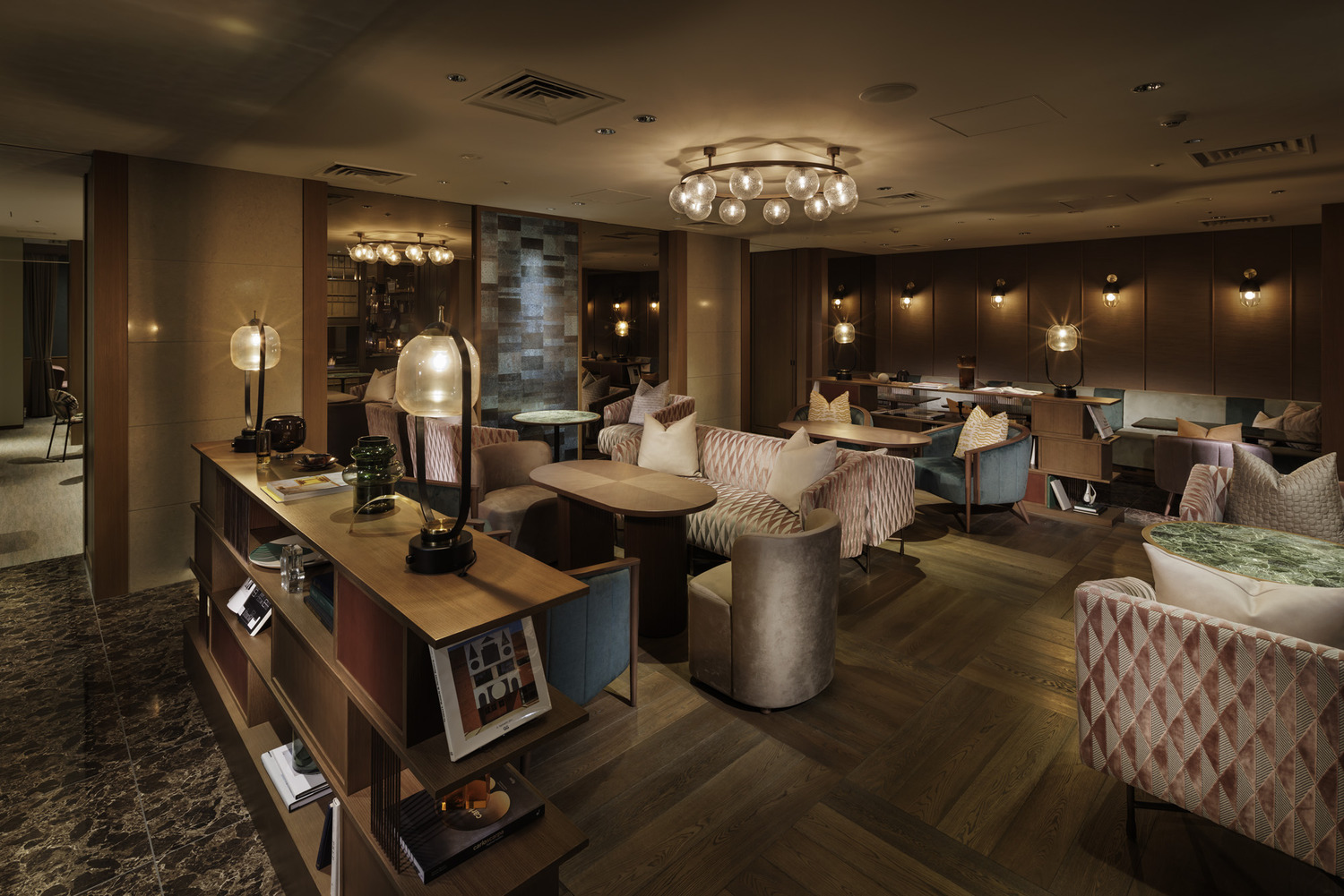 Art Deco-style restaurant interior with red cushioned booths, geometric metal dividers, warm lighting, and blue glassware. Elegant and inviting ambiance.