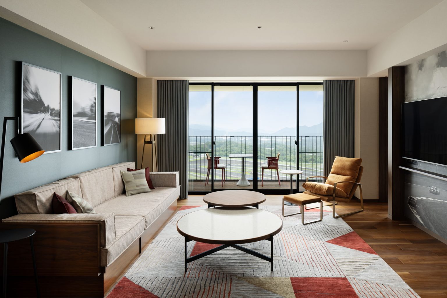 Cozy hotel bedroom with an open balcony offering a misty forest view. A small table with two chairs and glasses, conveying tranquility and relaxation.