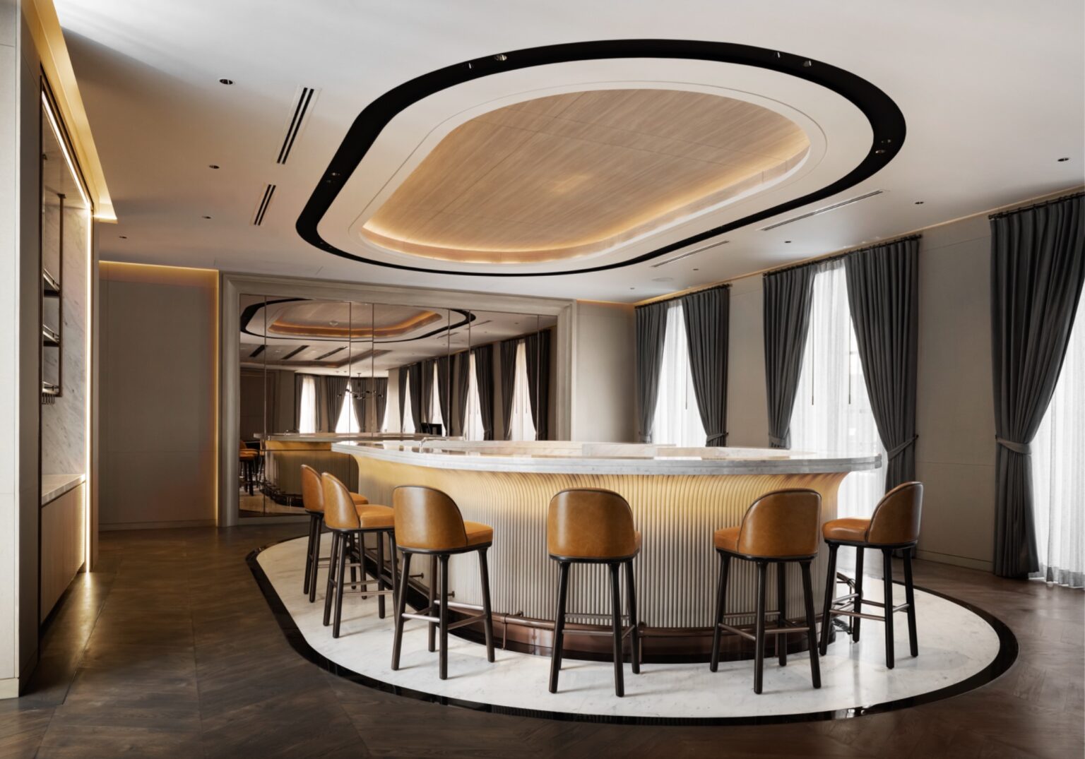 Elegant, modern private bar with a curved marble counter and leather stools, surrounded by large windows with gray curtains, ambient lighting, and sleek decor.