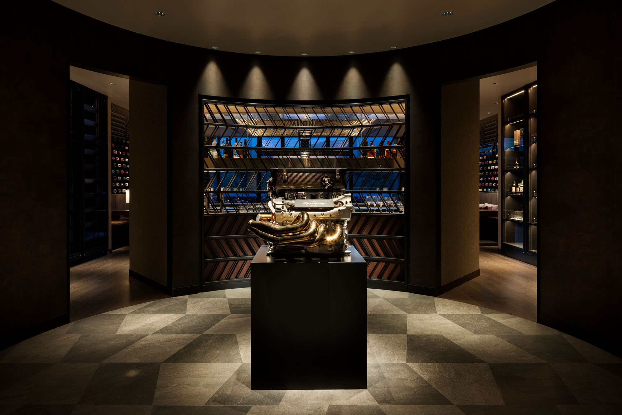 Luxurious hotel wine cellar with a golden sculpture centerpiece. Dim lighting, elegant shelving displays wine bottles. Sophisticated and inviting ambiance.