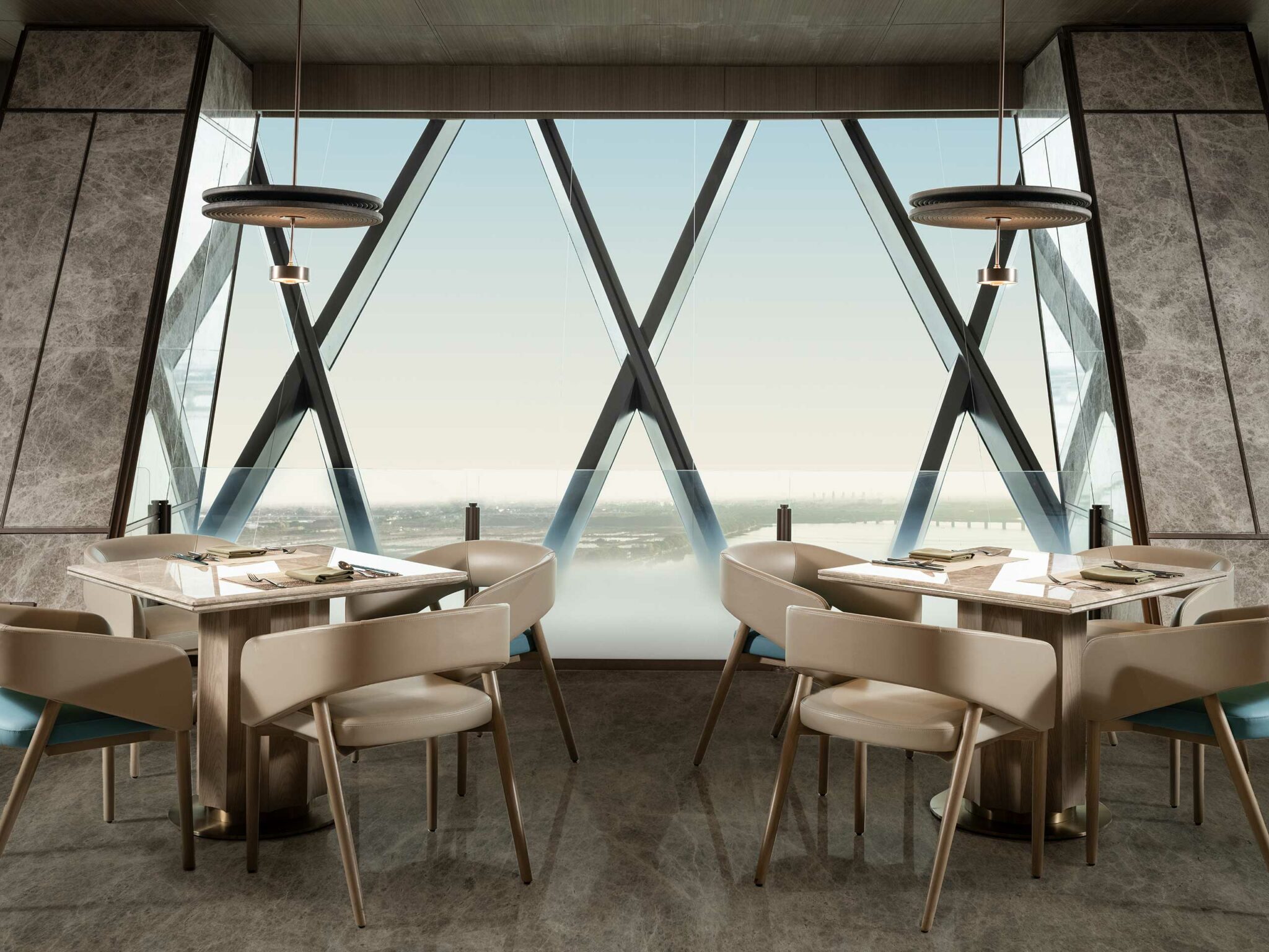 Modern hotel restaurant interior with beige chairs around square tables set for dining. Large windows with crisscrossing beams offer a panoramic city view.