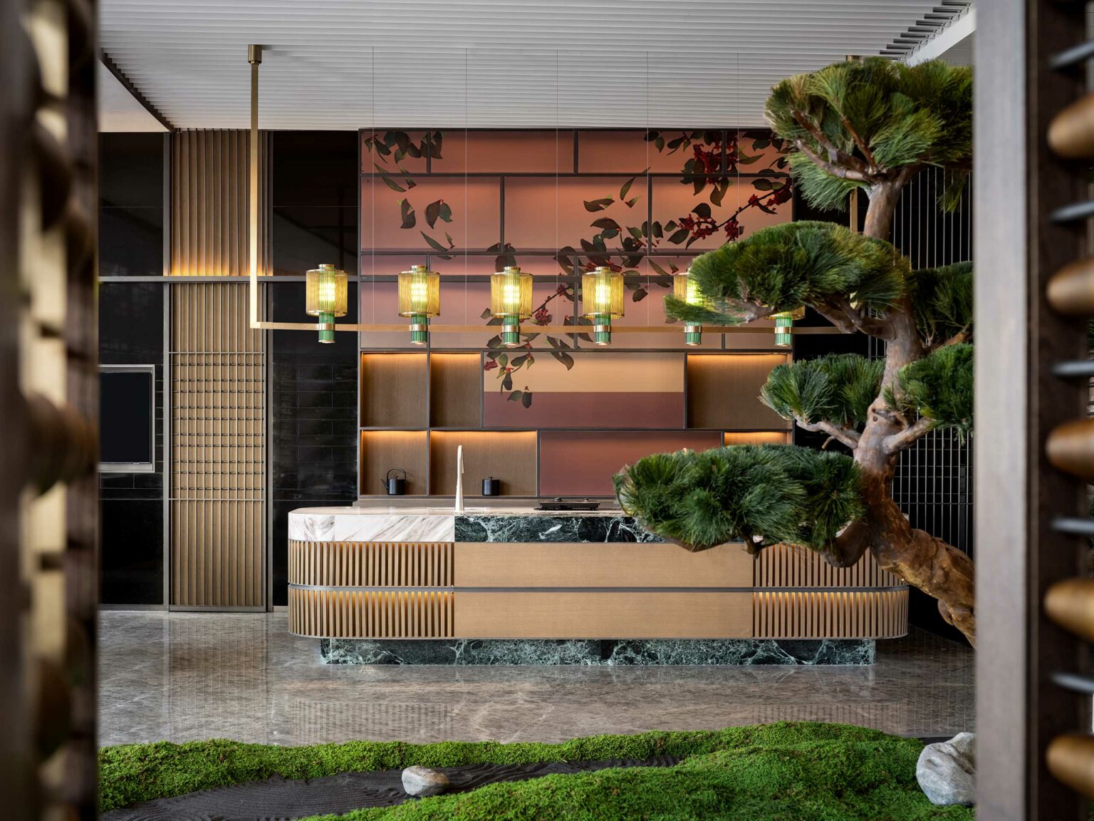 Luxurious modern hotel interior features a sleek reception desk with marble and wood accents, ambient pendant lights, and a bonsai tree, evoking elegance and serenity.