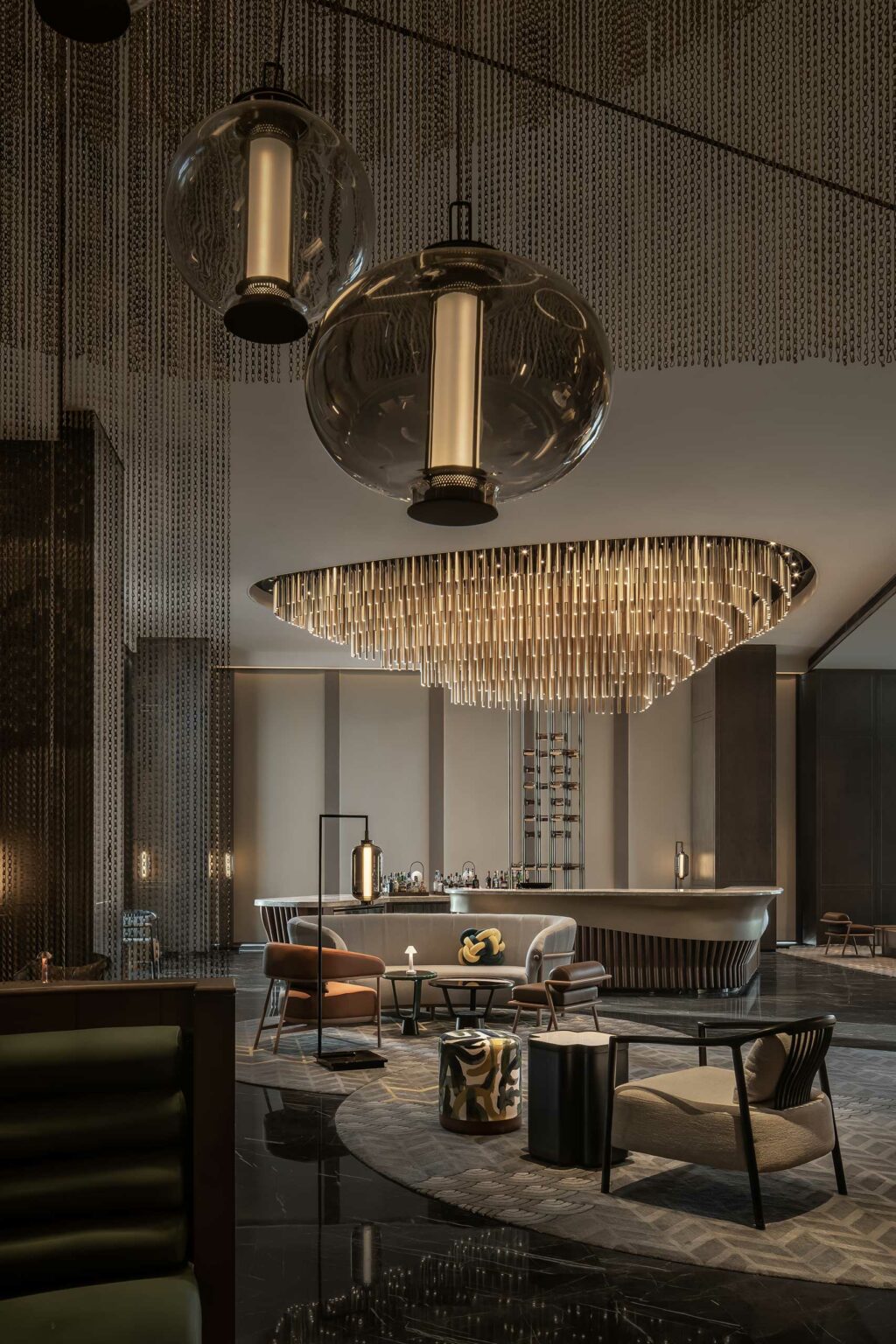 Luxurious hotel lounge with a stunning chandelier, sleek furniture, and warm lighting. The mood is elegant and sophisticated, inviting relaxation.
