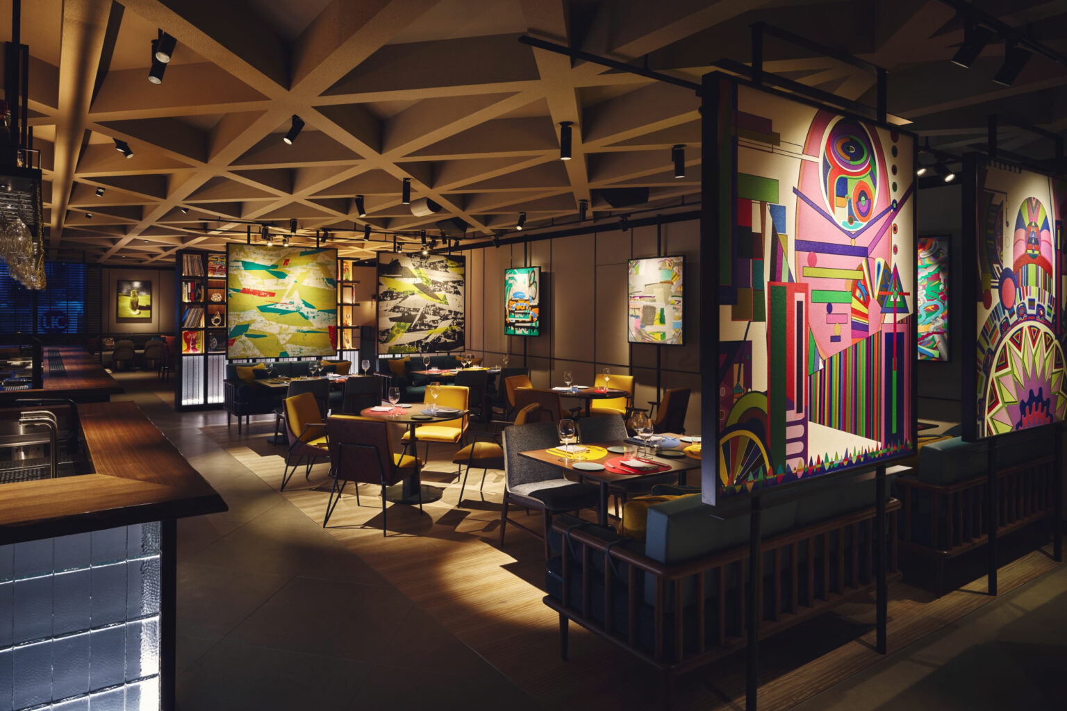Modern hotel restaurant interior with colorful abstract art on the walls. Warm lighting, cozy seating with yellow and gray chairs, and a geometric ceiling design.