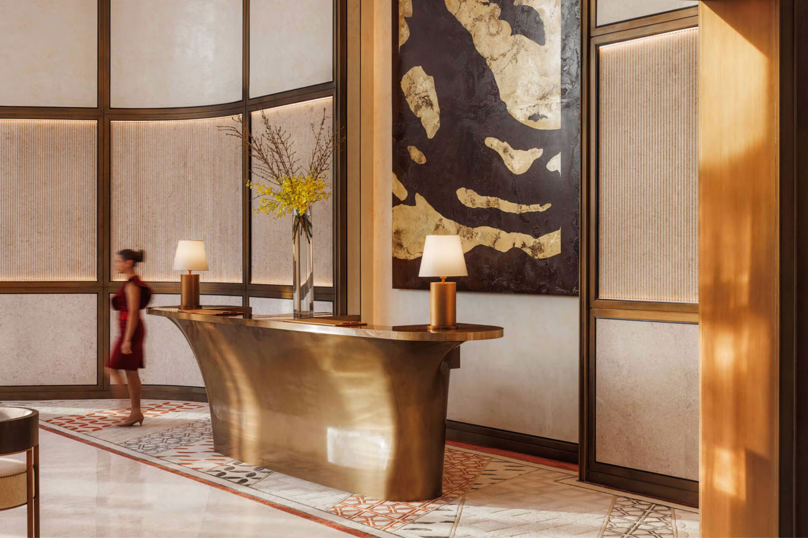 Luxurious hotel lobby with a curved bronze reception desk, modern lamps, and a large abstract painting. A person in a red dress walks past.