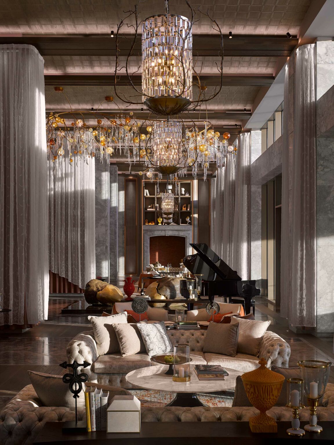 Luxurious resort lounge with high ceilings, a grand chandelier, plush sofas, and a piano. Soft light, opulent decor, and elegant ambiance create a refined atmosphere.