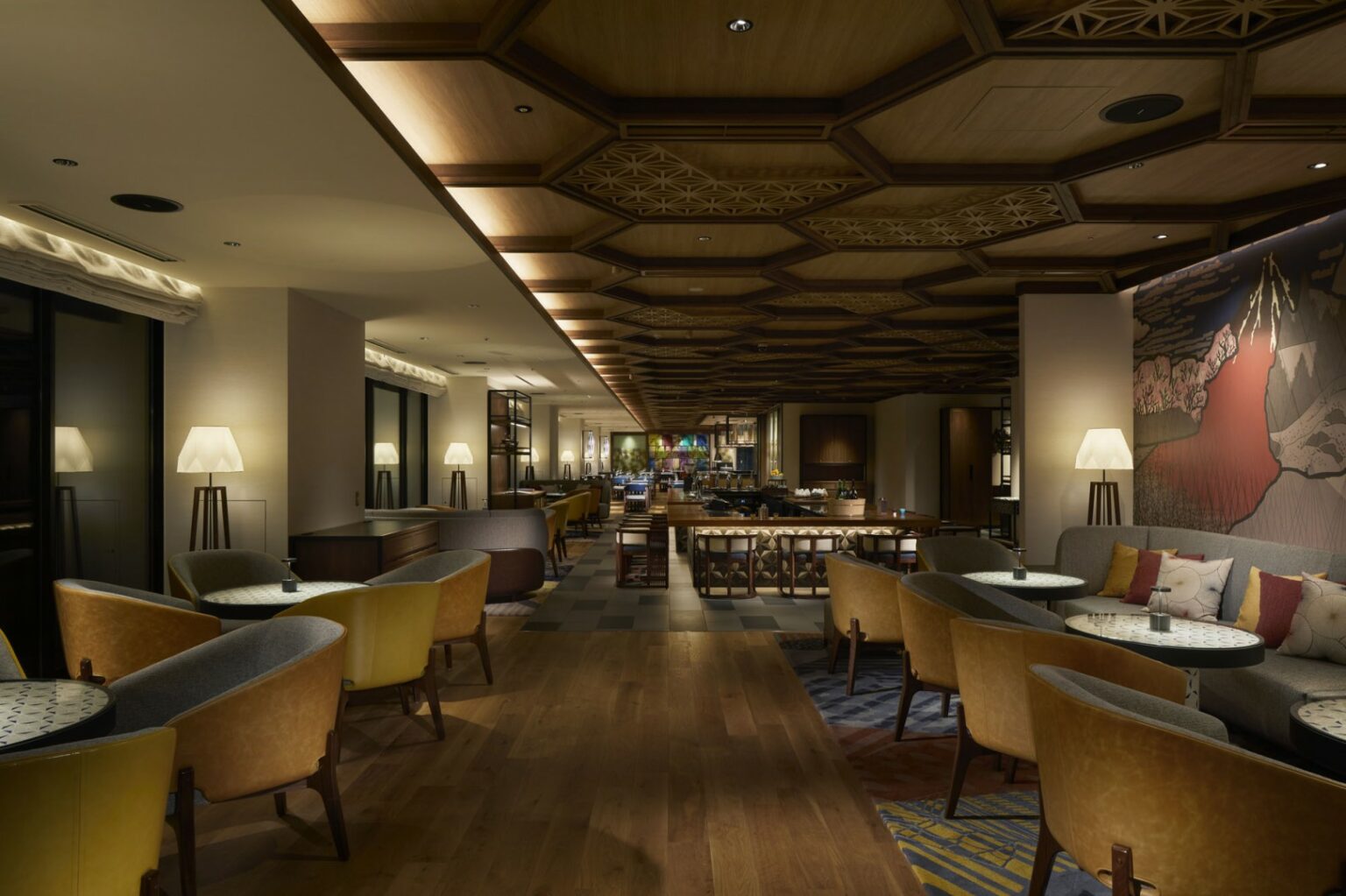 Sophisticated restaurant lounge with patterned wooden ceiling, warm lighting, and modern furnishings in neutral tones. The atmosphere is cozy and elegant.