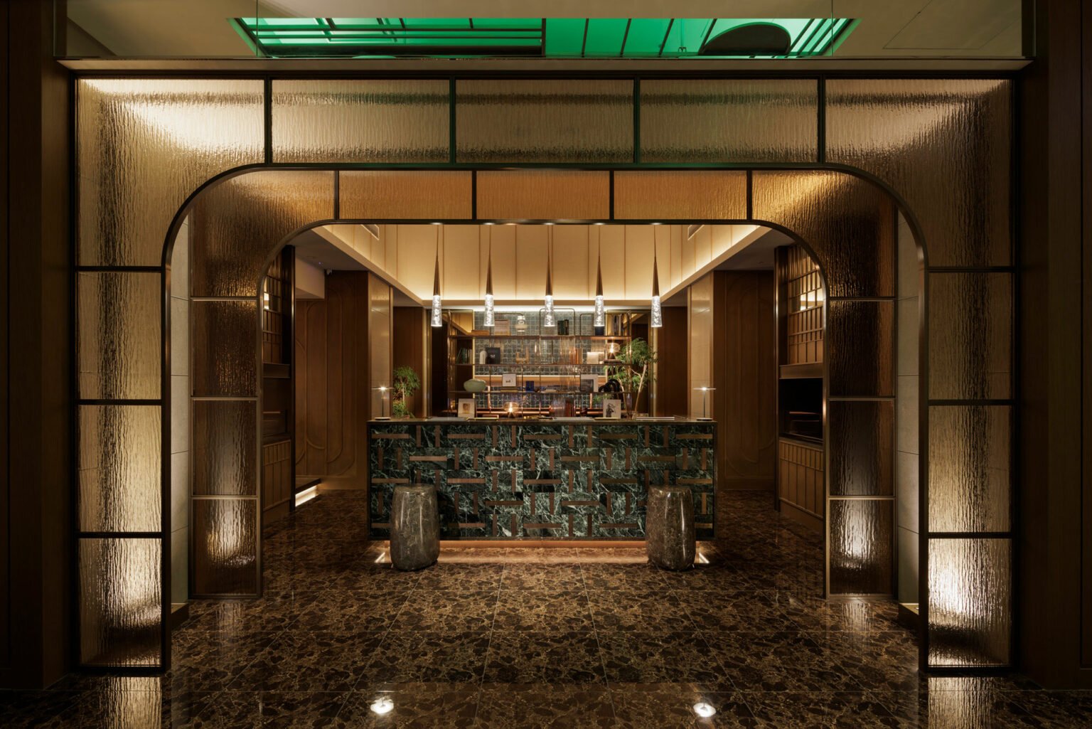 Elegant hotel bar interior with a marble counter surrounded by warm wood panels and soft lighting. Art Deco-style archway adds a sophisticated touch.