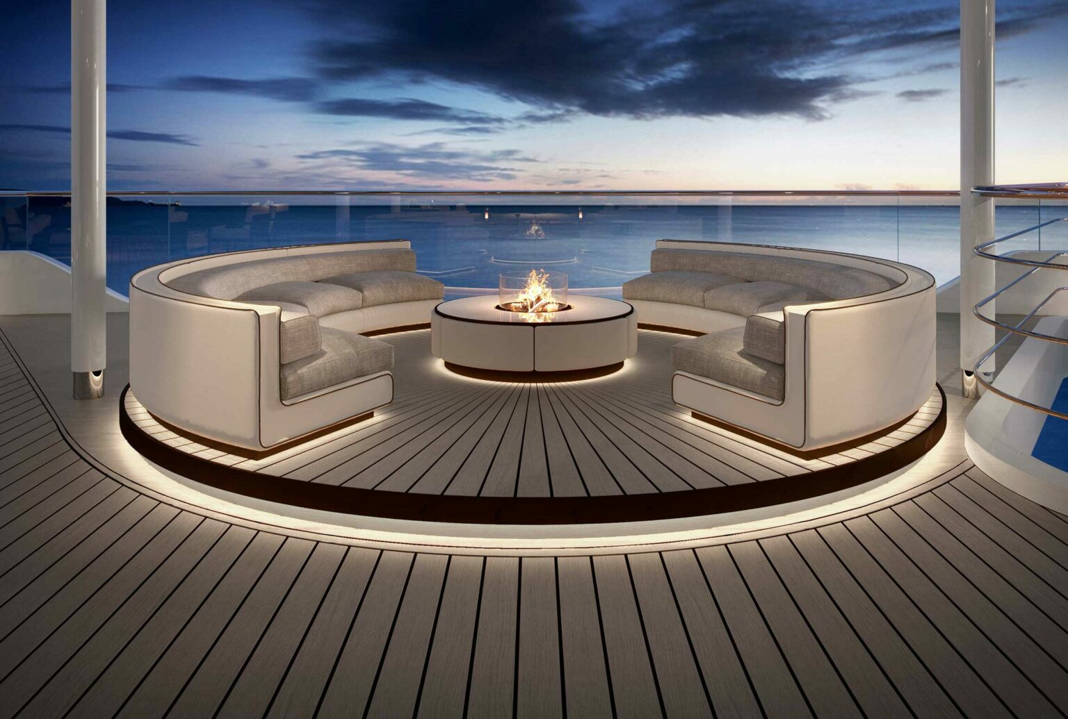 Luxurious cruise deck with curved sofas around a circular fire pit. Tranquil ocean and dramatic twilight sky create a serene and elegant ambiance.