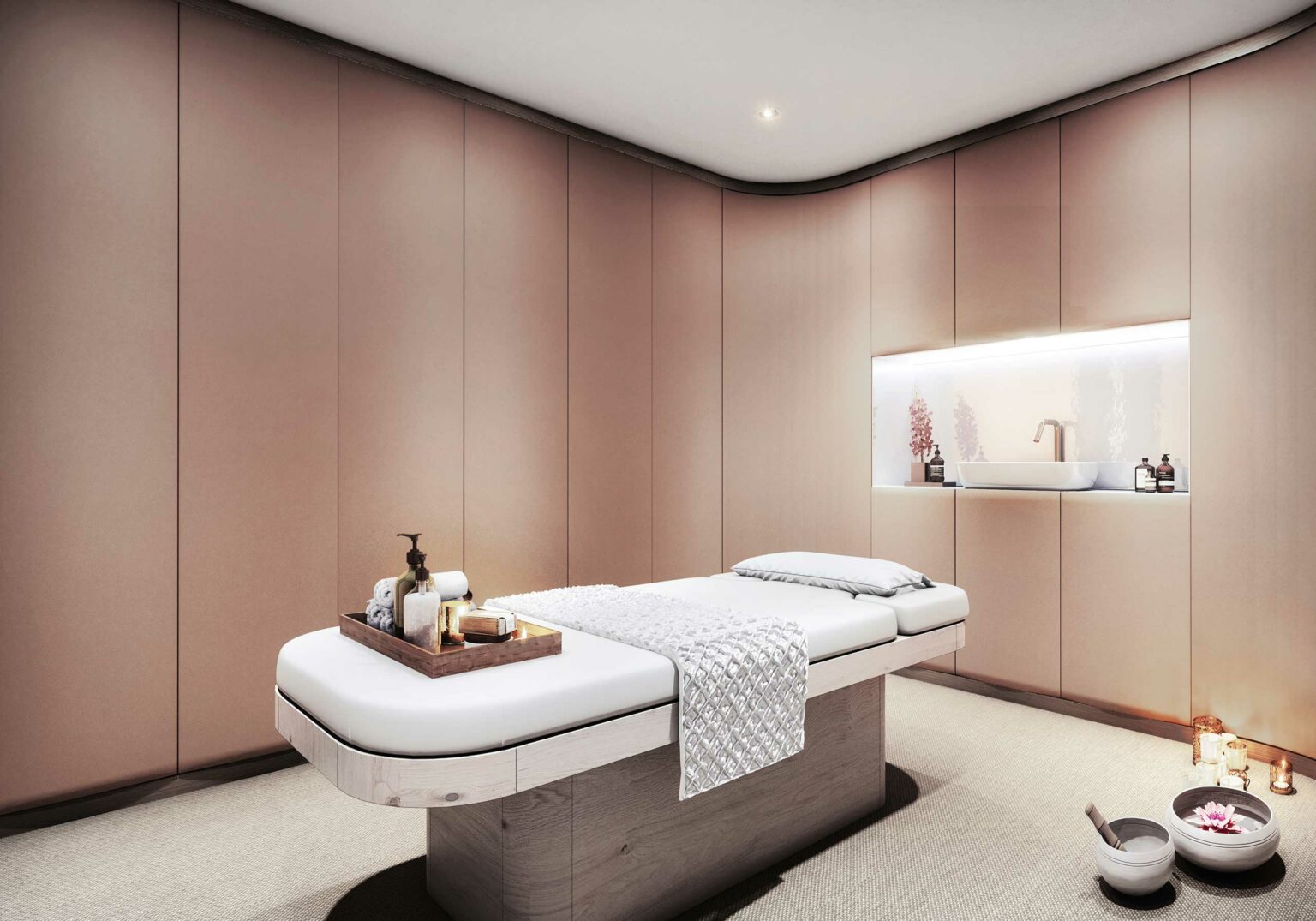 A serene cruise spa treatment room with a massage bed featuring a folded towel, wooden tray, and candles. Soft lighting and warm beige tones create a calming atmosphere.
