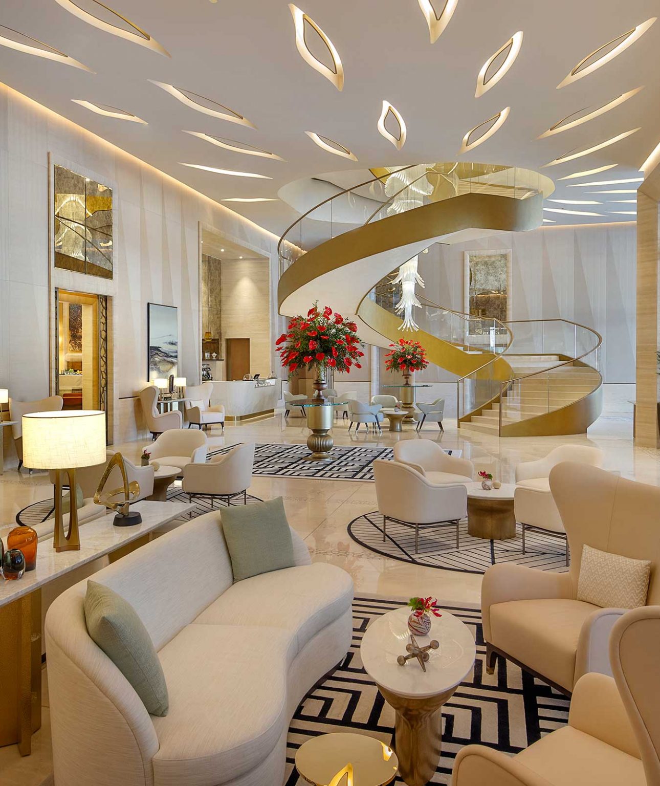 Luxurious hotel lobby with a grand spiral staircase, elegant seating, abstract art, and soft lighting. Modern, spacious, and inviting atmosphere.