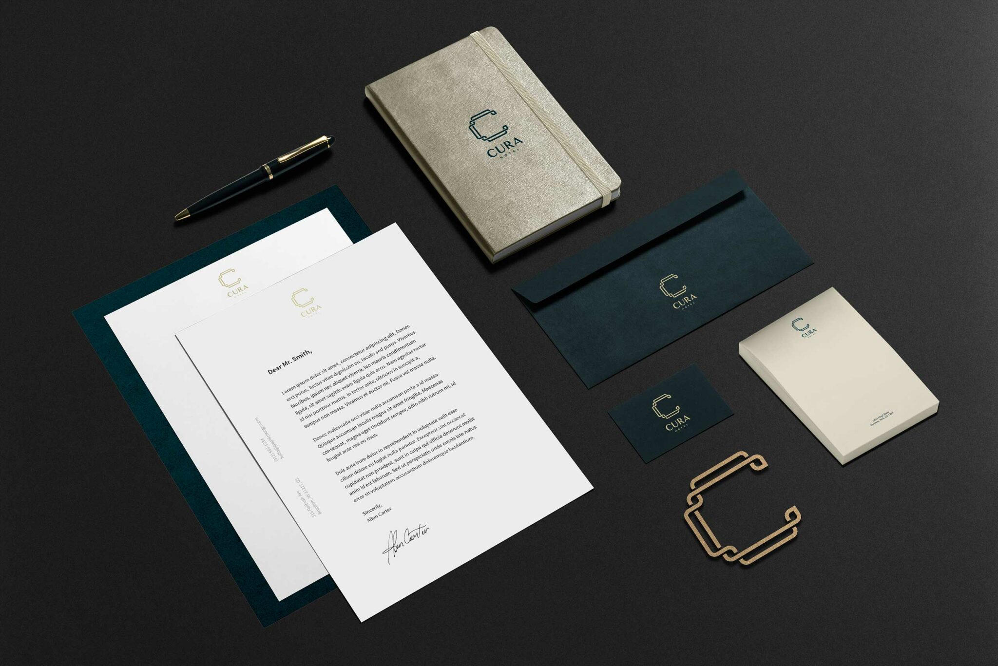Elegant stationery set on a dark background, featuring a letter, envelopes, business cards, and a notebook, all branded with the 
