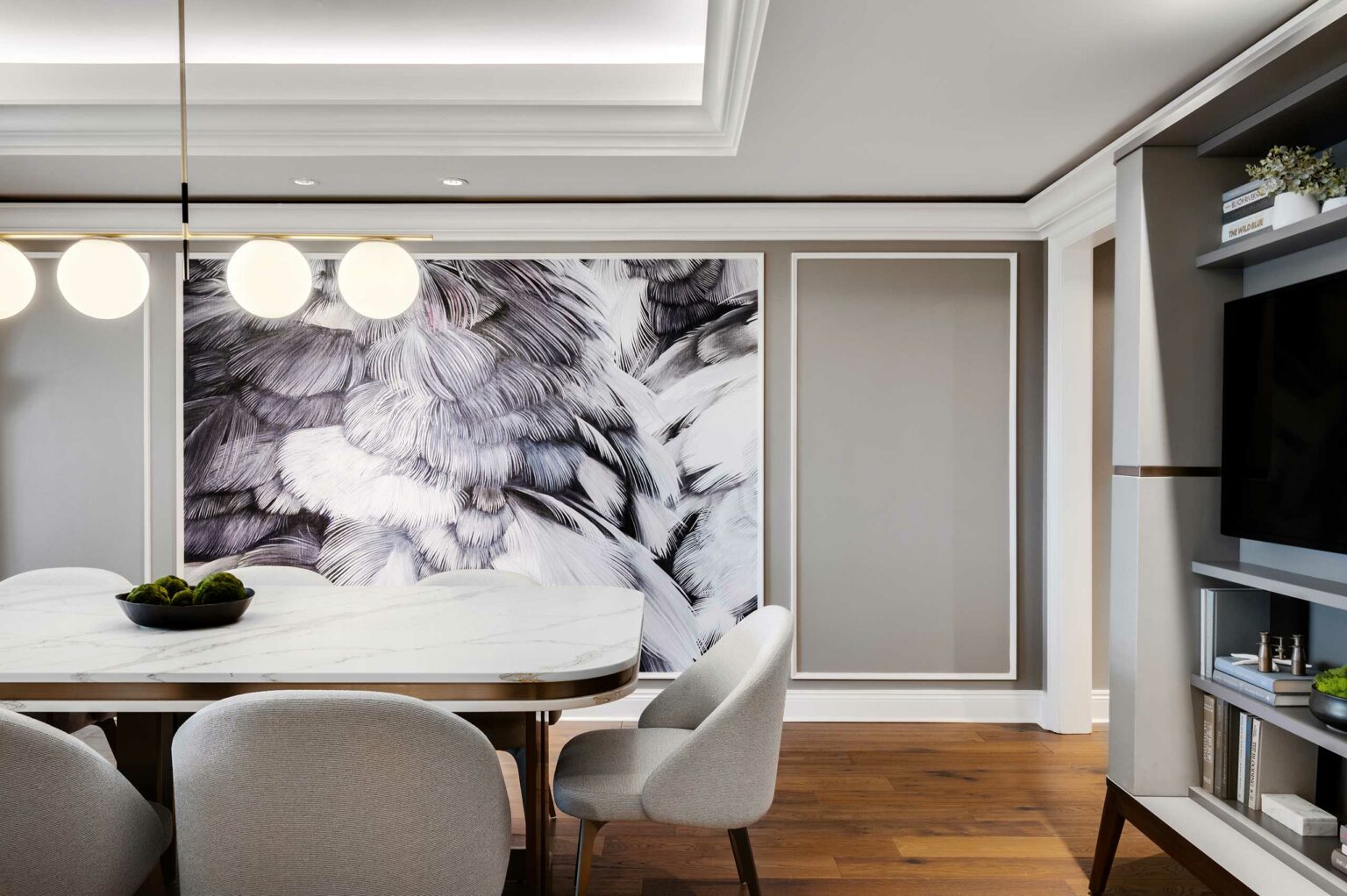 Modern suite dining room with a large abstract feather mural on the wall, sleek white marble table, gray upholstered chairs, and a stylish pendant light.