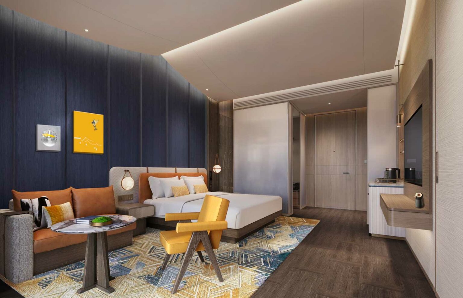 Modern hotel room with a plush double bed, tan sofa, and yellow chair. Dark paneled walls, colorful geometric rug, and minimalist decor evoke comfort.