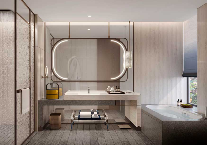 Modern guest room bathroom with a large oval mirror above a sleek vanity, illuminated by gentle lighting. A bathtub is on the right, creating a serene ambiance.