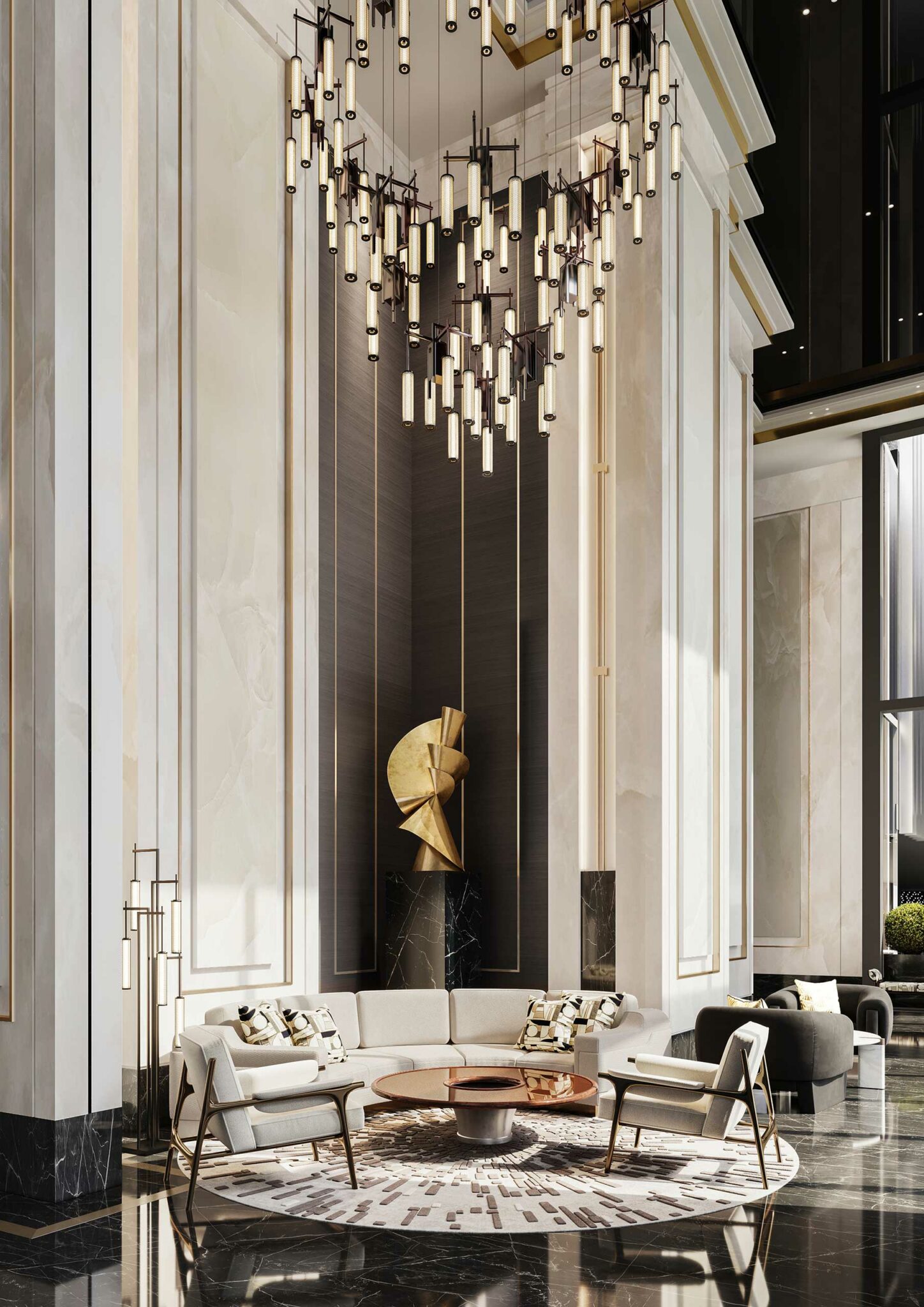 Elegant residential lobby with high ceilings, featuring a modern chandelier, abstract gold sculpture, and a circular seating area with neutral-toned furniture.