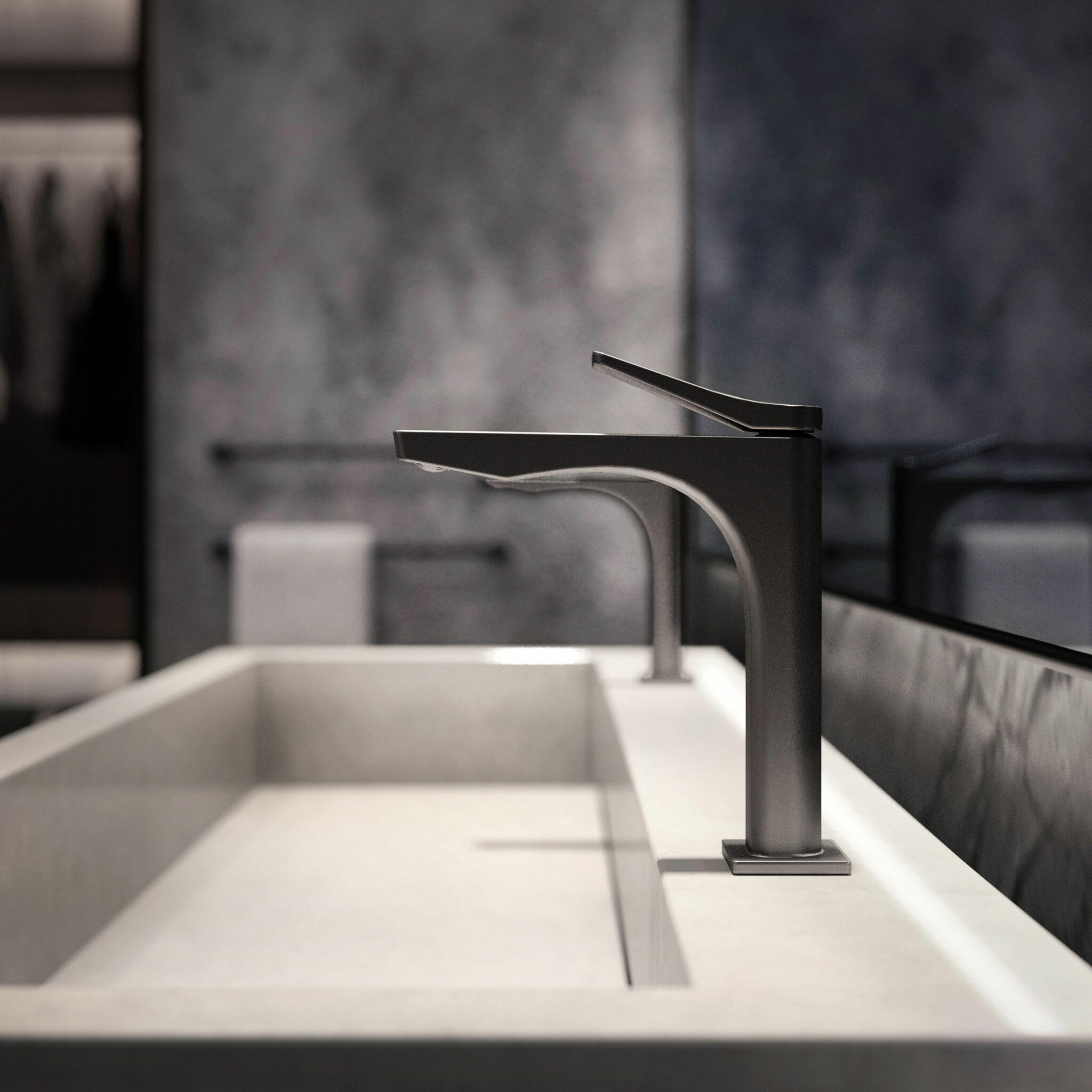 Modern bathroom sink with a sleek, matte black faucet and light marble countertop. The blurred gray wall and towel add an elegant, minimalist feel.